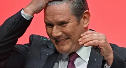 Keir Starmer se limpia la brillantina que un opositor interno de su partido le arrojó cuando subía al escenario del congreso laborista
