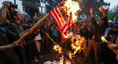 Manifestantes queman banderas de Estados Unidos luego de la decisión sobre el acuerdo nuclear con Irán