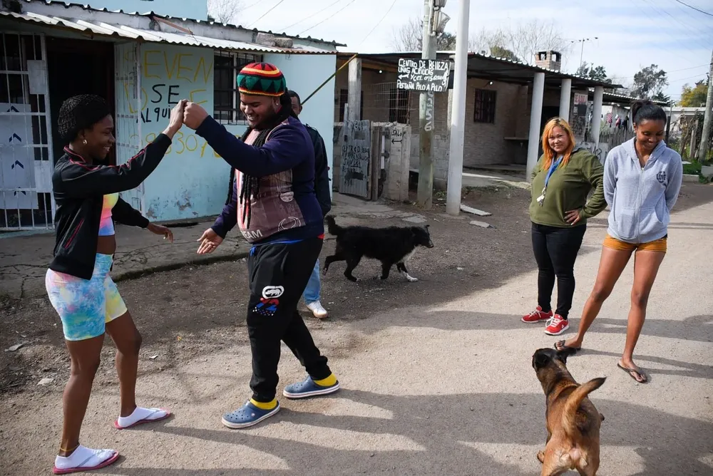 En el barrio suena la bachata a todo volumen, hay una iglesia pentecostal y olor a arroz frito.
