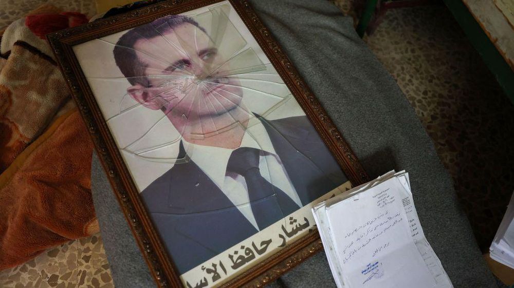 Un retrato roto y en el suelo de Bashar al Assad.