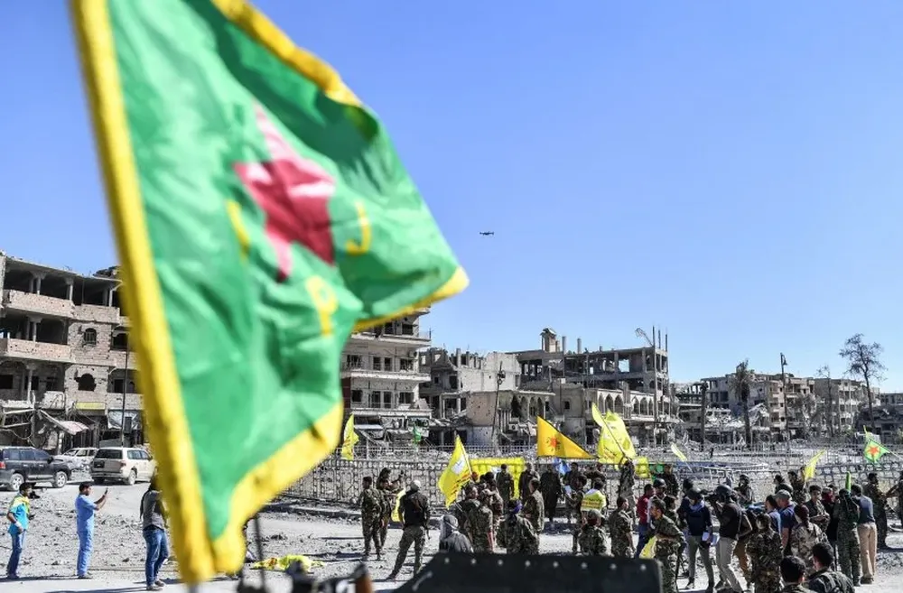 Members of the Syrian Democratic Forces (SDF), backed by US special forces, gather at the iconic Al-Naim square in Raqa on October 17, 2017. US-backed forces said they had taken full control of Raqa from the Islamic State group, defeating the last jihadist holdouts in the de facto Syrian capital of their now-shattered caliphate. / AFP / BULENT KILIC