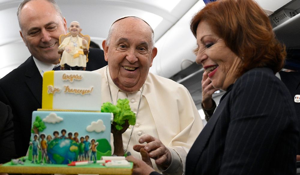 El papa Francisco cuando celebró sus 88 años con la torta que le regalaron periodistas en el avión de regreso de su viaje a Córcega