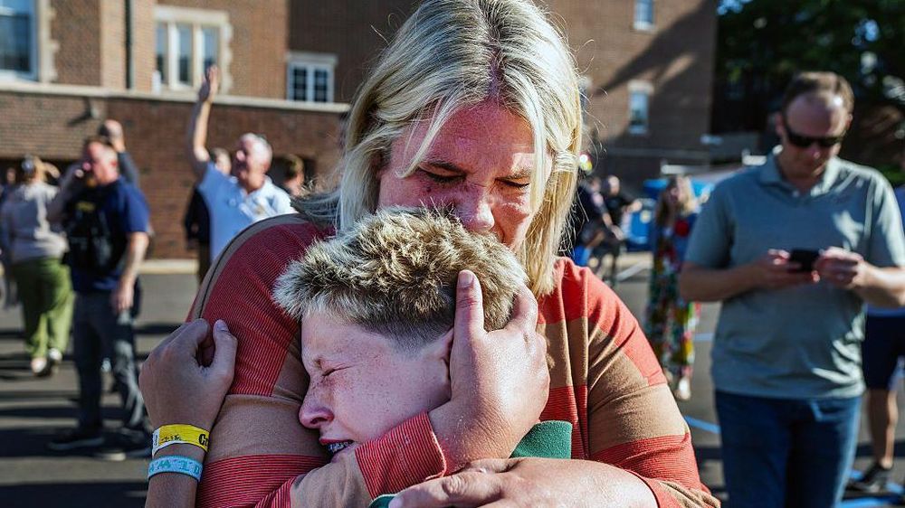 Una madre abraza a su hijo tras un tiroteo en la Iglesia de la escuela católica Anunciación, en Minneapolis, Minnesota.