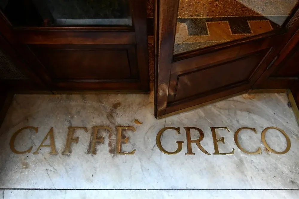 Un mozo limpia el servilletero de plata original del café