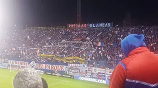 Hinchas de Nacional con una bandera de Peñarol