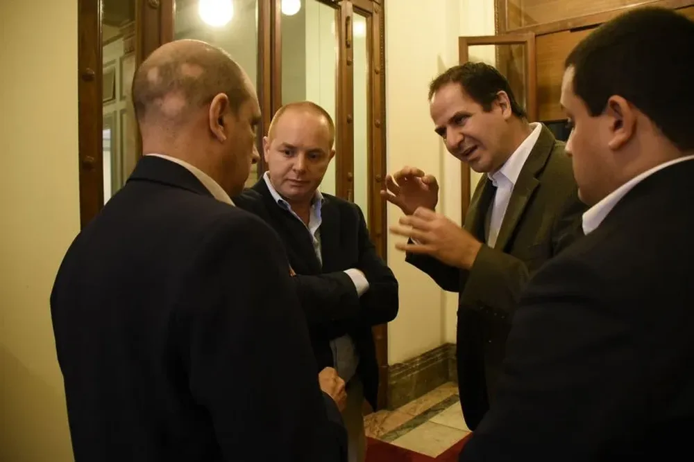 Federico Eguren (centro), Rodrigo Barcelona (izquierda) y Marcos García (derecha) discuten con el diputado Daniel Radío