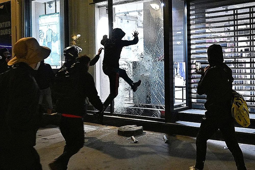 Varias personas rompen un escaparate el domingo en París.