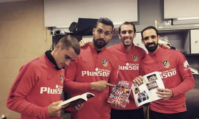 Godín y sus compañeros con el libro del uruguayo