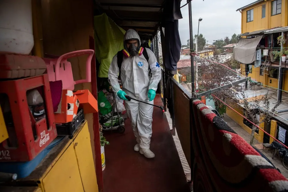 Un trabajador municipal limpia y desinfecta una comunidad de bajos ingresos por la pandemia del coronavirus