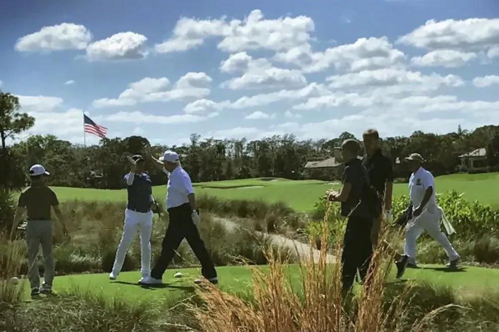 Trump, el tercero desde la izquierda, choca su mano con Abe (segundo desde la izquierda) durante un partido de golf en el resort de Mar a Lago, propiedad del ahora presidente.