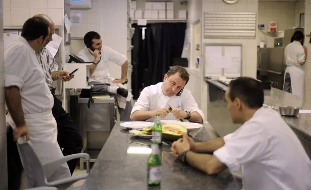 Berasategui atiende el teléfono mientras come en su restorán, situado en la villa vasca norteña de Lasarte