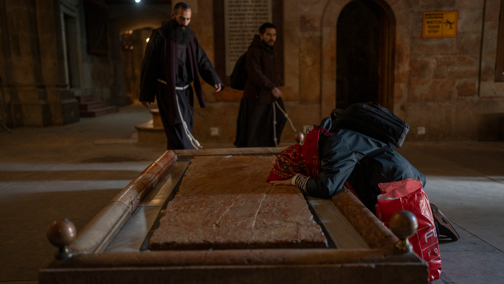 Una mujer rezando ante la Piedra de la Unción en la Iglesia del Santo Sepulcro.