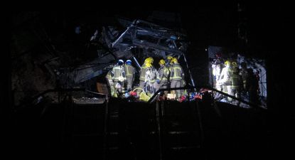 Los bomberos trabajan dentro del vagón de tren siniestrado.
