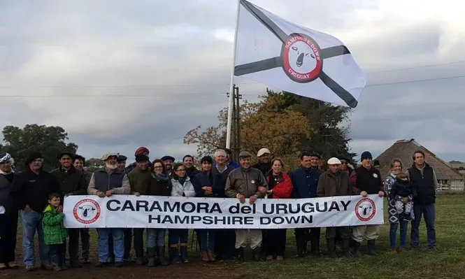 Los participantes de la Gira Hampshire Down con la bandera de la raza