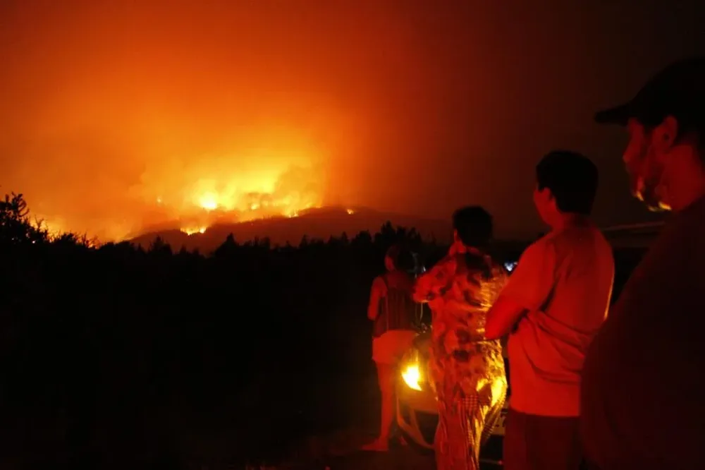 Miembros de los organismos de emergencia trabajan en el control y extinción de un incendio forestal este domingo en la provincia de Cauquenes región del Bio Bio (Chile)