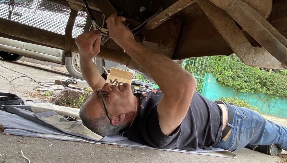 Jorge Bado reparando la casa rodante de la familia de Fernando Corbo y Paola Godoy