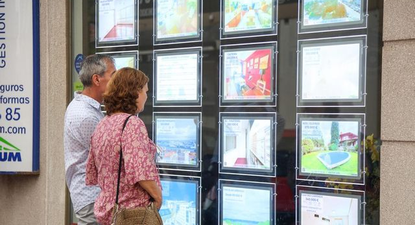 Una pareja ve avisos clasificados en una inmobiliaria