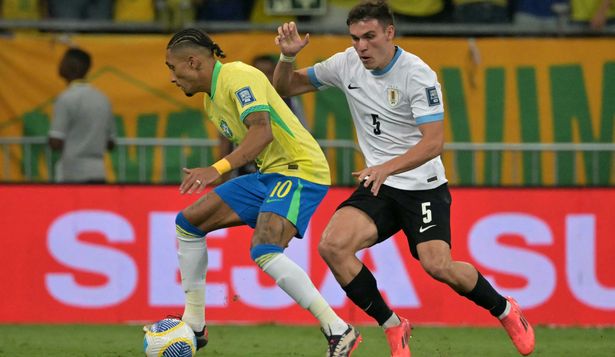 Manuel Ugarte de la selección de Uruguay ante Raphinha de Brasil