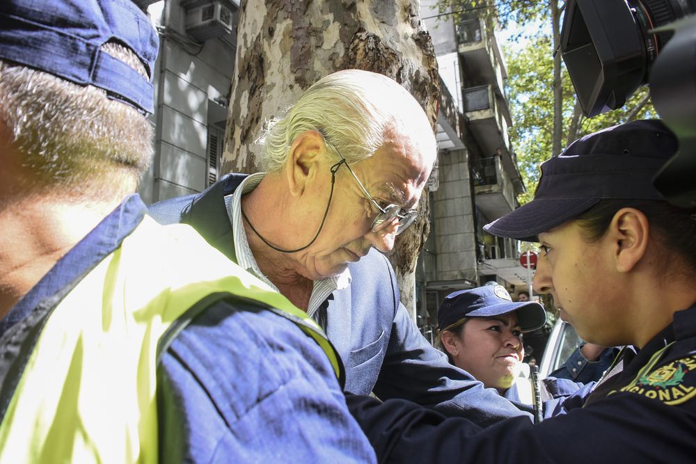 Pablo Carrasco saliendo de una audiencia, en medio de una manifestación de damnificados de Conexión Ganadera