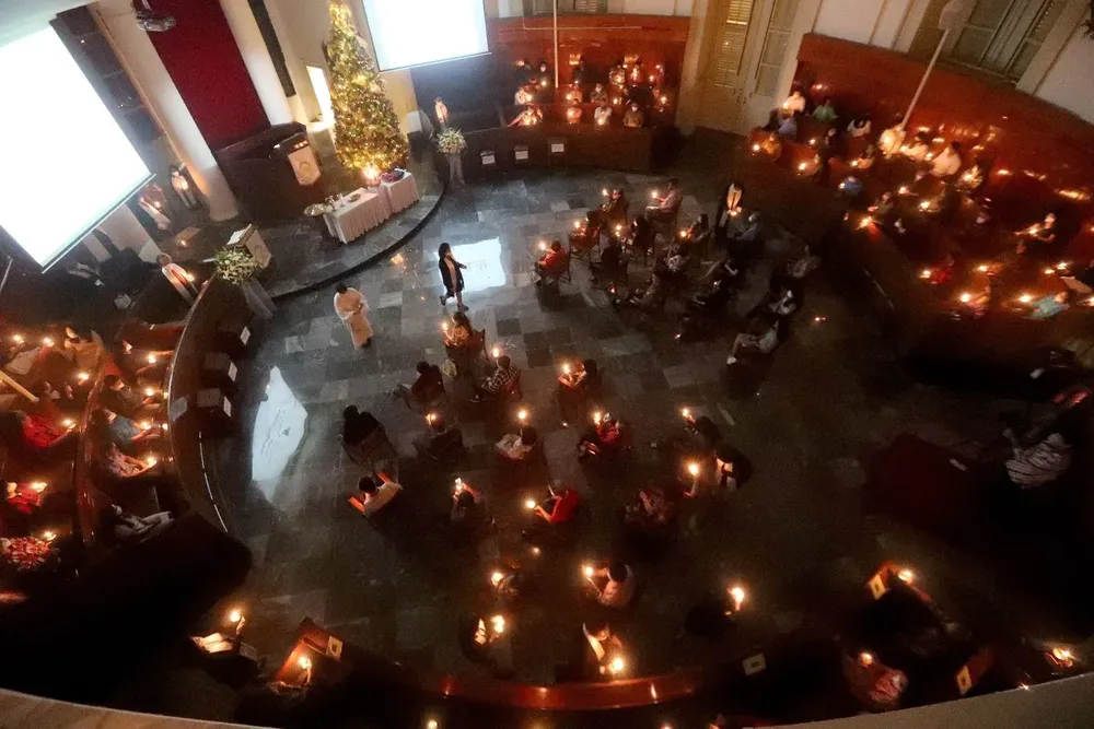 Devotos católicos indonesios sostienen velas durante una misa de Nochebuena en la iglesia Immanuel en Yakarta, Indonesia.