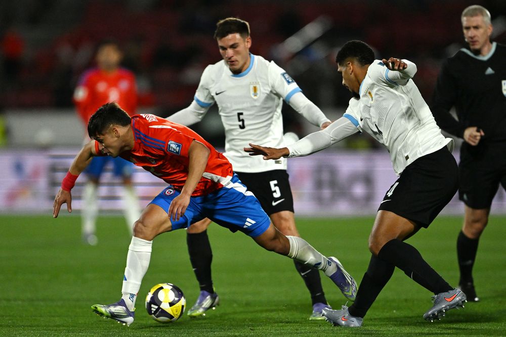Fabián Hormazábal de Chile pelea el balón con Manuel Ugarte y Ronald Araujo de Uruguay por Eliminatorias