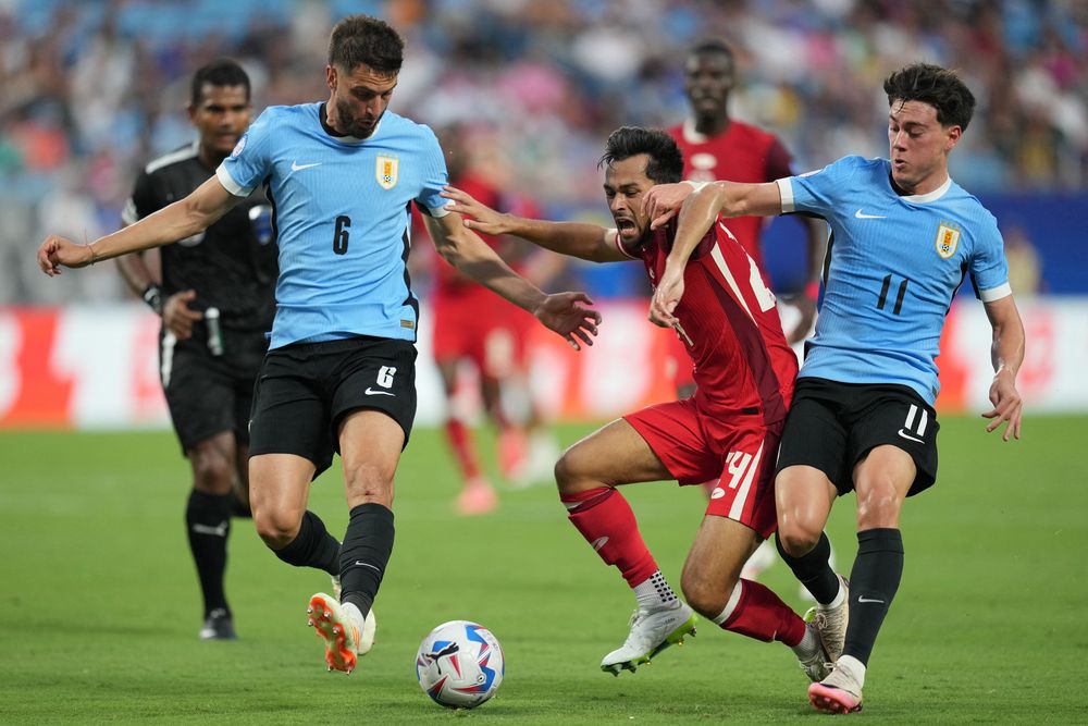 Mathieu Choiniere de Canadá ante Rodrigo Bentancur y Nahitan Nández de la selección de Uruguay