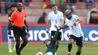 Robson Matheus de Bolivia disputa un balón con Rodrigo Aguirre de Uruguay por Eliminatorias