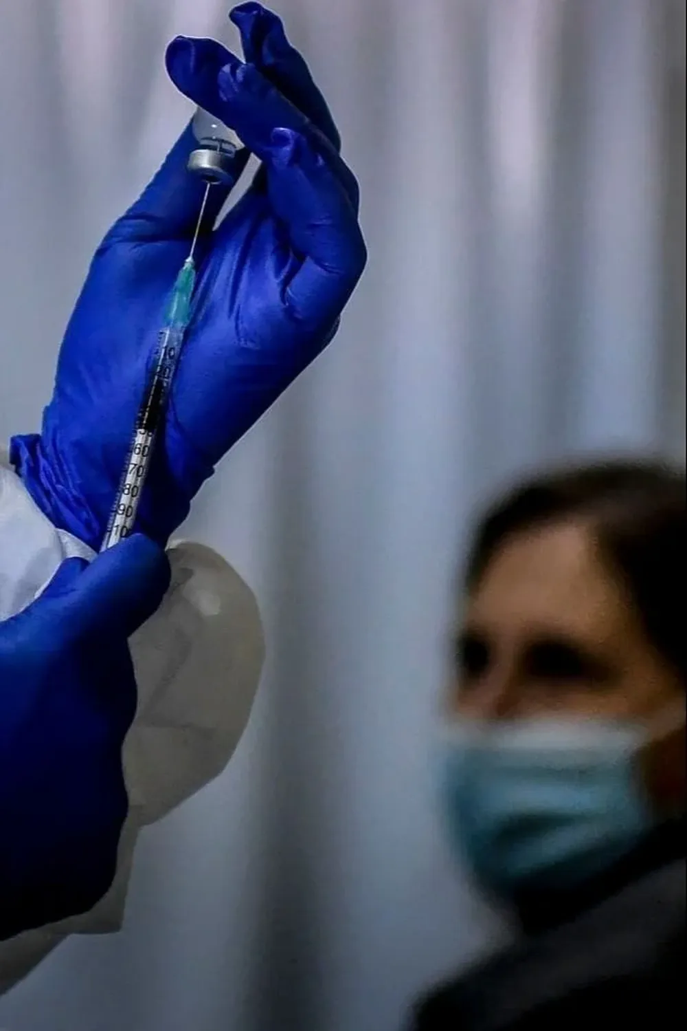 Funcionario de la salud a punto de vacunar a un paciente