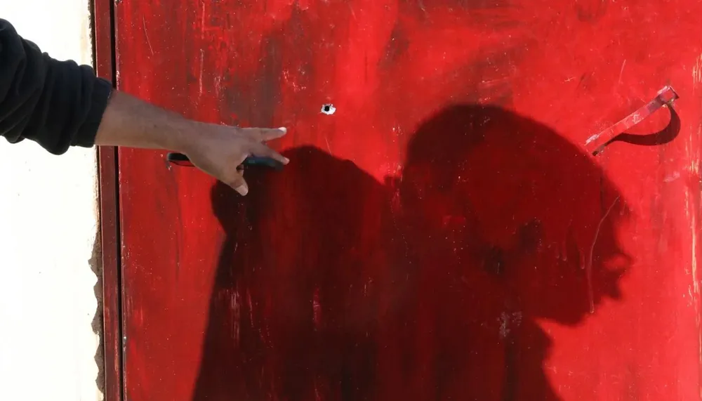 Un hombre palestino muestra unos orificios de bala en el lugar donde Jana Majdi Zakarneh falleció por un disparo en la cabeza por parte de tropas israelíes