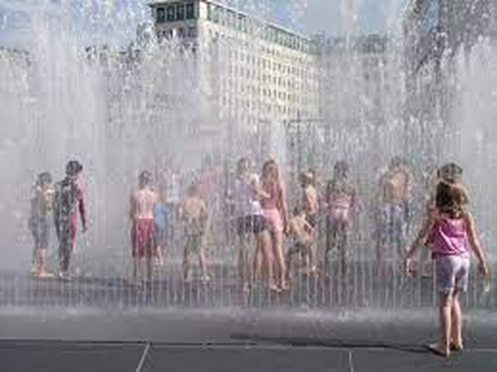 Los niños disfrutan de las fuentes en un día tórrido en España.