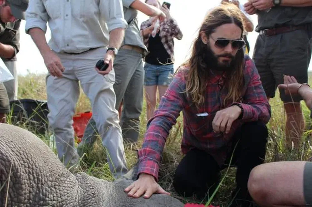 Jared Leto, durante su viaje a Sudáfrica, tocando un rinoceronte