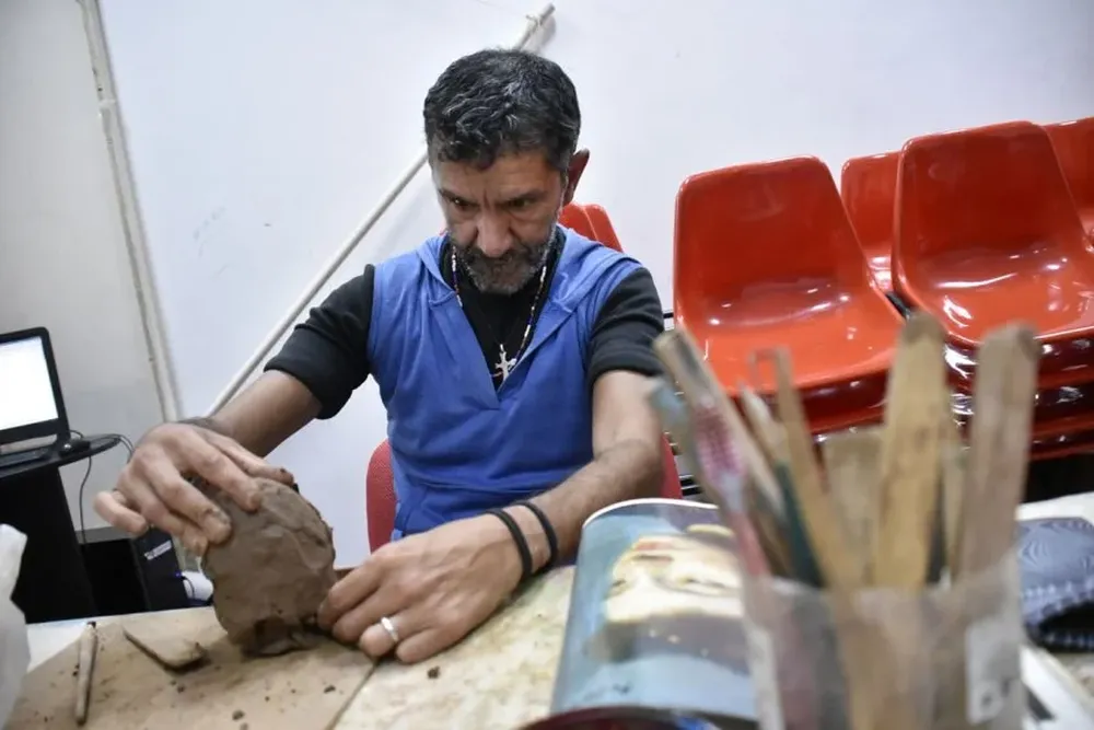Miguel (48) trabaja en una escultura sobre el barro