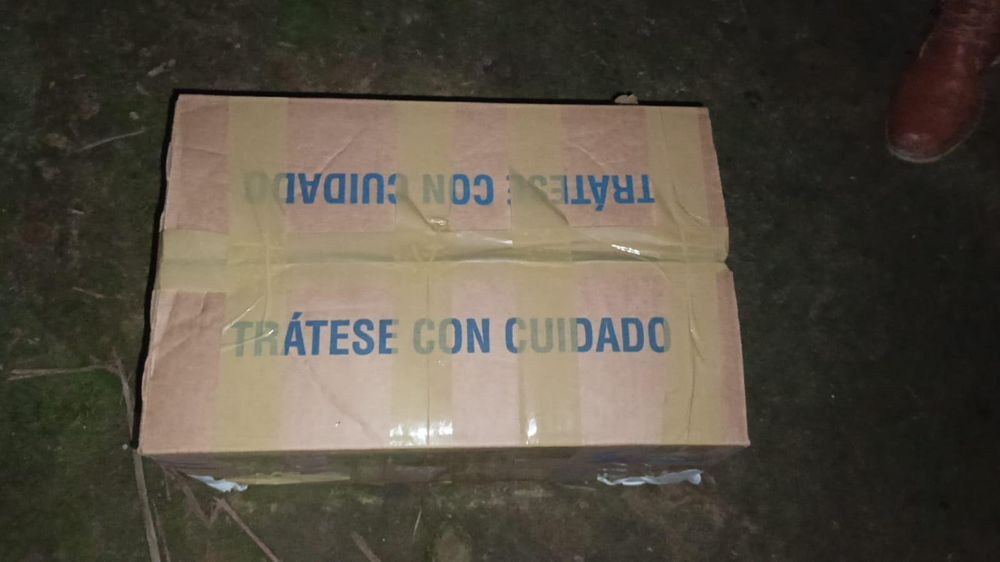 La caja de cartón cerrada con cinta y con un mensaje en azul que dice "Trátese con cuidado".