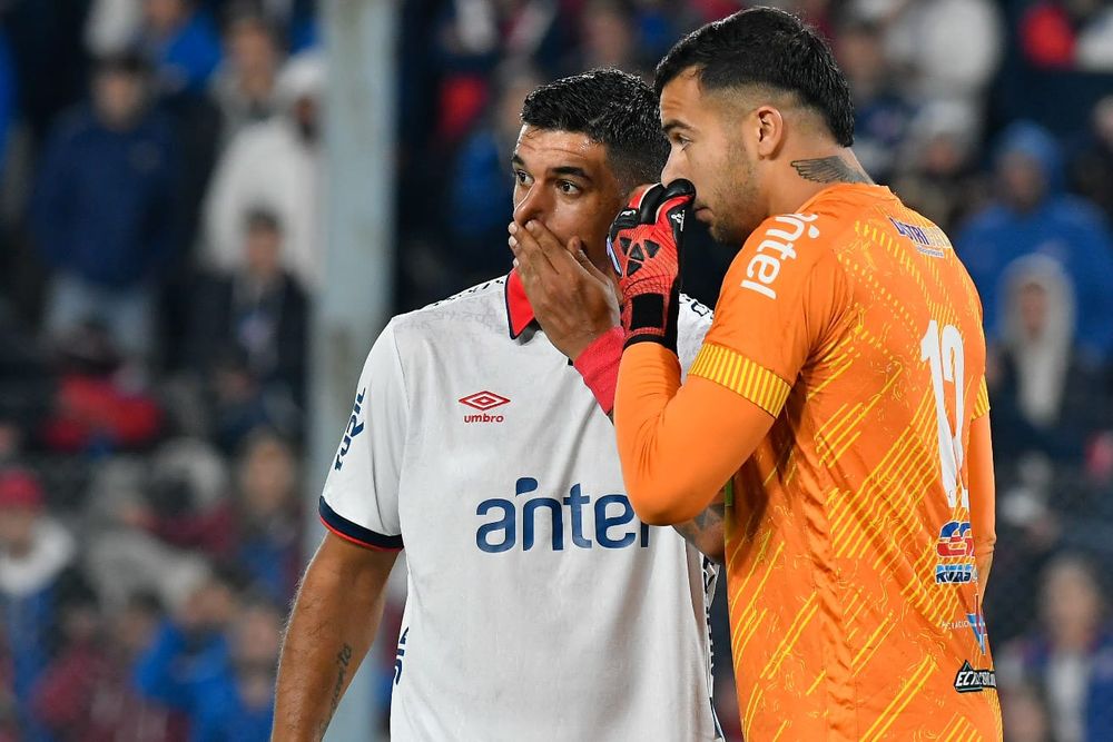 Diego Polenta de Nacional y Pedro González de Fénix conversan en pleno partido