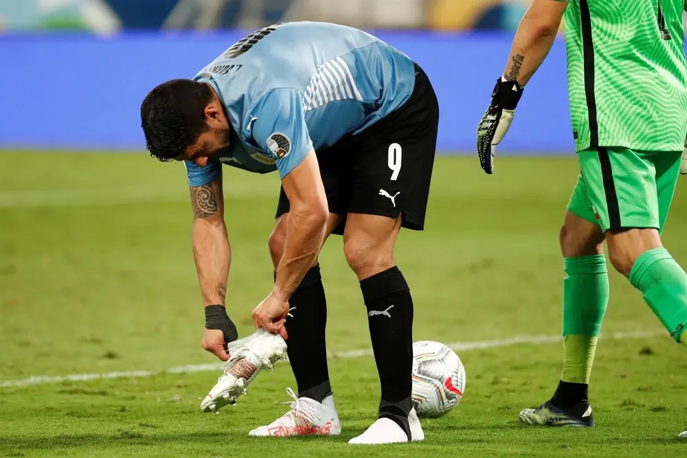 Luis Suárez se acomoda el zapato en el área chilena
