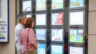 Una pareja ve avisos clasificados en una inmobiliaria