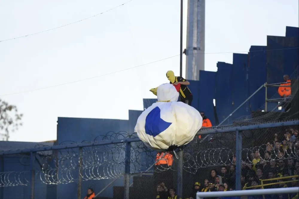 La gallina inflable y un hincha en lo alto el tejido en la tribuna de Peñarol en el Gran Parque Central