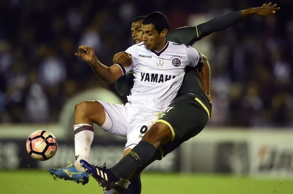 Luiz Otavio, el jugador de la polémica, pelea la pelota con José Sand (9)