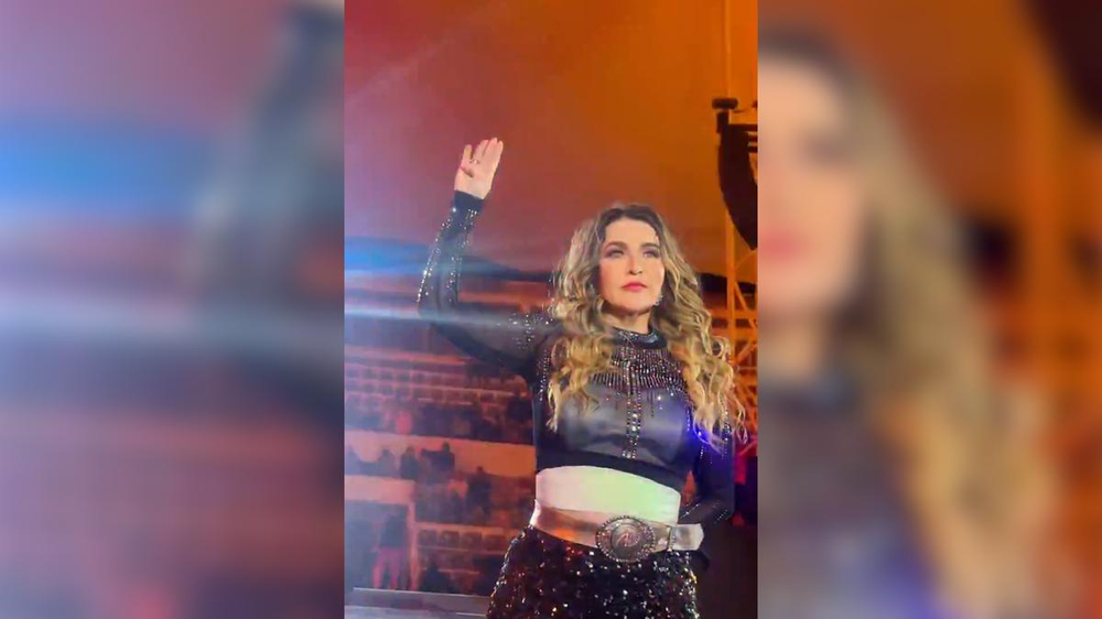 La cantante mexicana Alicia Villarreal haciendo el gesto de pedido de auxilio en pleno recital.