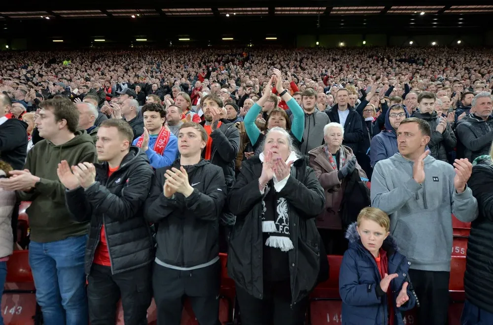 Los hinchas de Liverpool de pie en apoyo al ídolo de un clásico rival