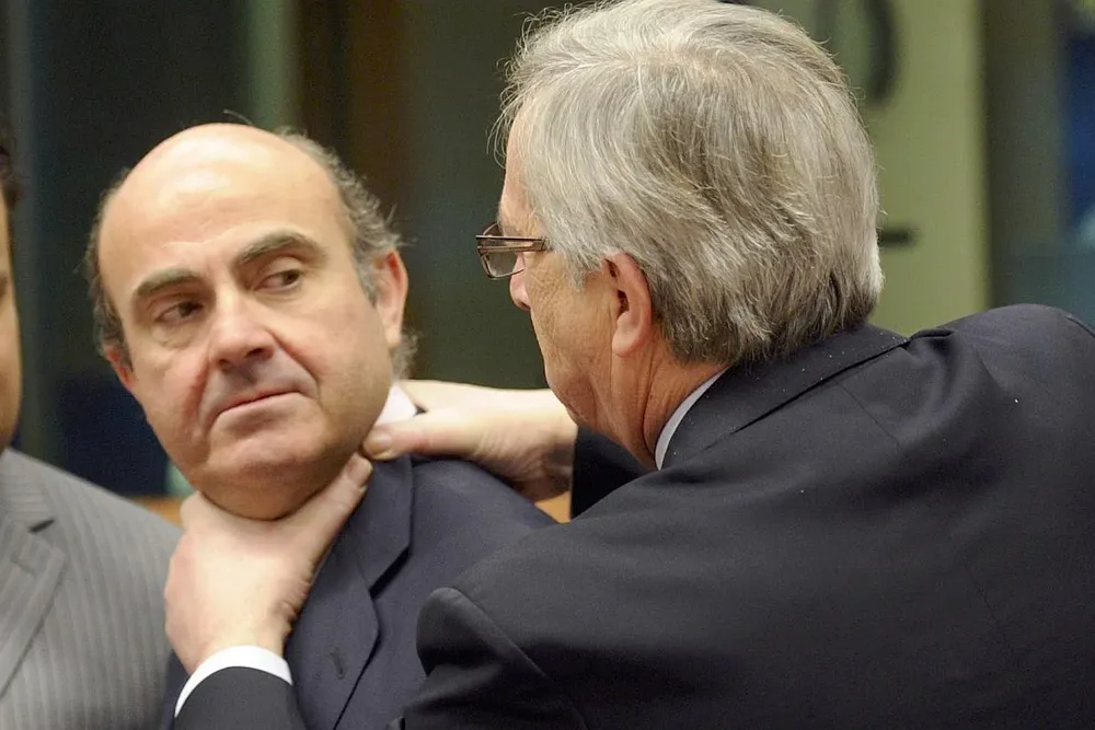 El primer ministro de Luxemburgo, Jean-Claude Juncker, bromea con el ministro de Economía español, Luis de Guindos, tomándolo del cuello