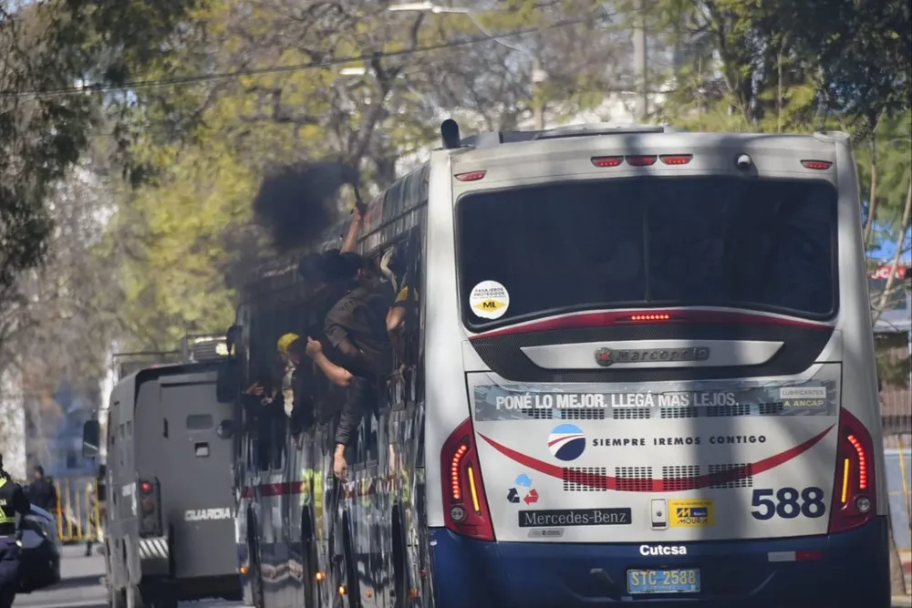 Hinchas de Peñarol camino al GPC encienden una bengala en el ómnibus que los traslada desde el Mercado Modelo al estadio tricolor