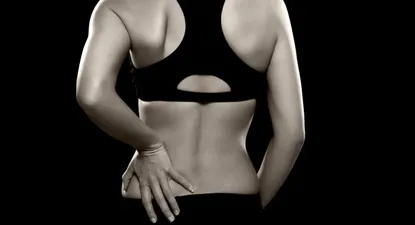 Una mujer padece de lumbalgia.