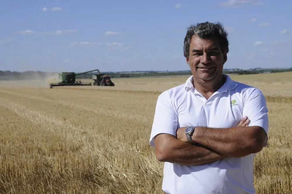 Marcelo delante de la trilla de trigo en una chacra en la que ya se había sembrado una pradera.