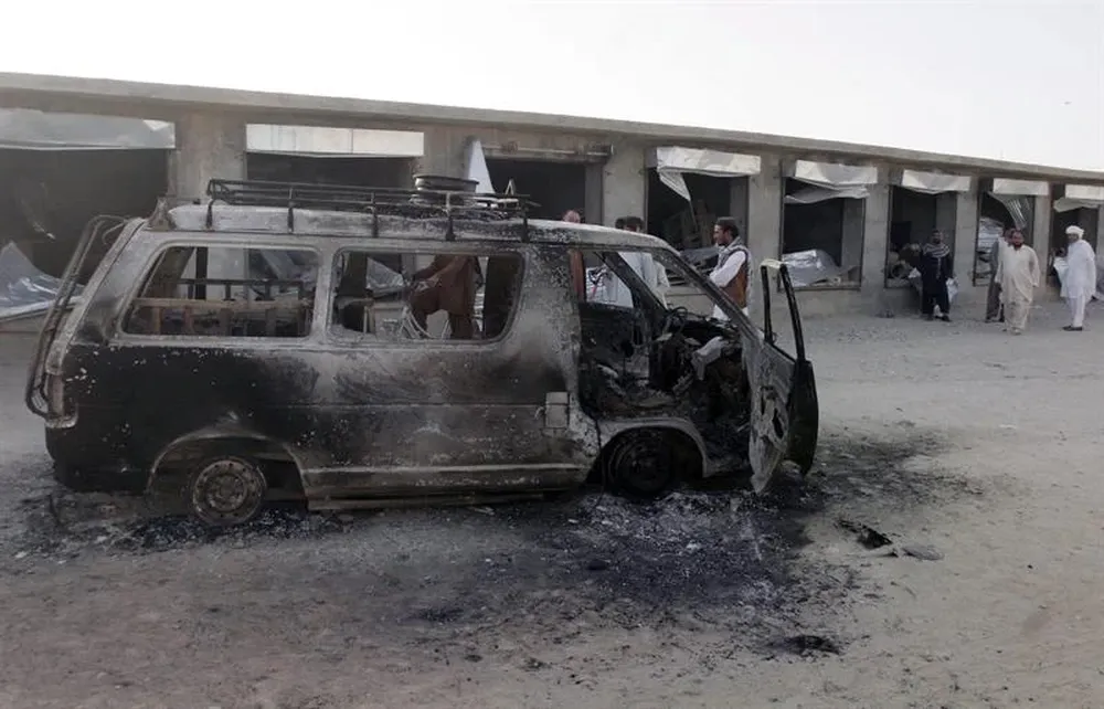 Afganos supervisan los daños en un mercado situado cerca de la base militar conjunta polaco-estadounidense