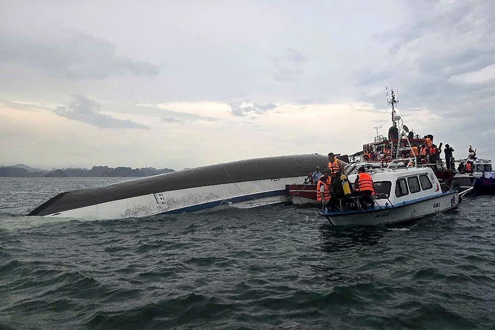 Vietnam: personal de socorro reunido alrededor de un barco turístico volcado durante una operación de búsqueda y rescate en la bahía de Ha Long, provincia de Quang Ninh.