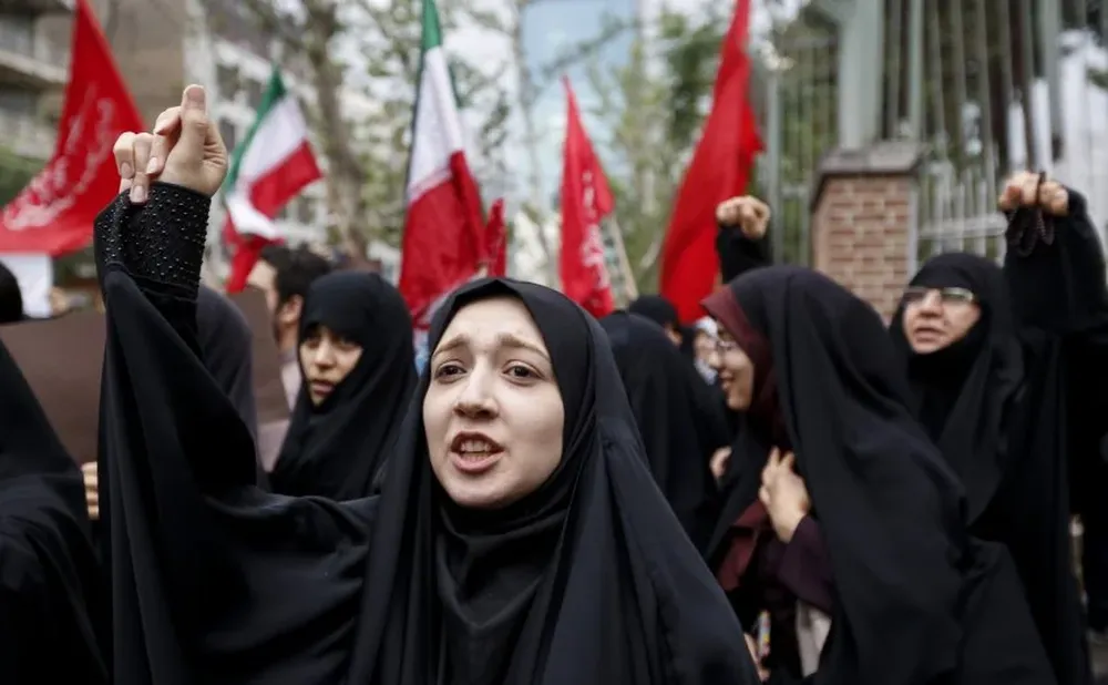 Mujeres iraníes entonan consignas durante una manifestación antiestadounidense frente a la sede de la embajada de Estados Unidos en la capital, Teherán, el 9 de mayo de 2018. Los iraníes reaccionaron el 19 de mayo con una mezcla de tristeza, resignación y desafío al retiro del presidente estadounidense Donald Trump del acuerdo nuclear, con fuertes divisiones entre los funcionarios sobre la mejor manera de responder.Para muchos, la decisión de Trump el martes de retirarse del histórico acuerdo nuclear marcó la sentencia de muerte final por la esperanza creada cuando se firmó en 2015 que Irán podría finalmente escapar de décadas de aislamiento y hostilidad de Estados Unidos.ATTA KENARE / AFP