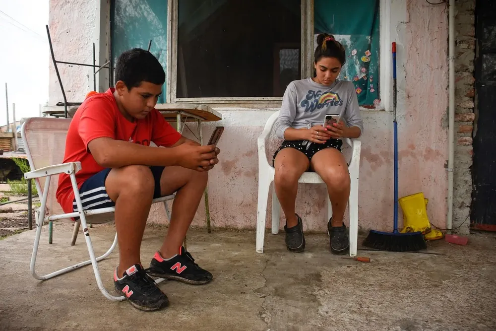 Christian está en 1° y Aldana en 2° de la UTU; los dos hermanos siguen sus clases en simultáneo con los datos móviles de un celular