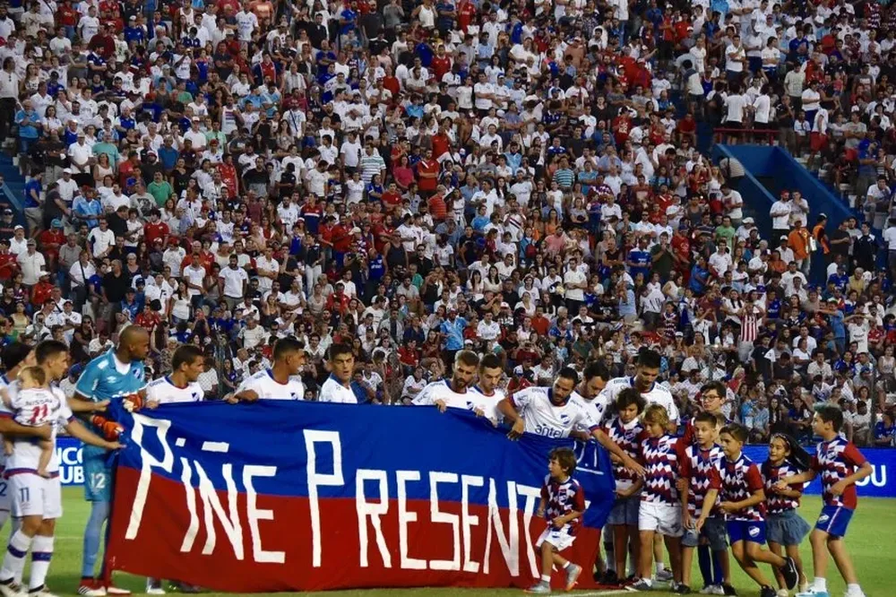 Los jugadores de Nacional con una pancarta al salir a la cancha