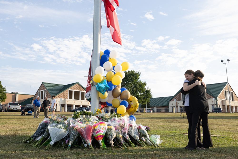 Dos alumnos se abrazan frente al memorial por las víctimas del tiroteo en la escuela de Georgia